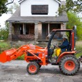 LOW MILEAGE, HIGH IDEALS  Edith Floyd, founder of 'Growing Joy' gardens in Detroit, drives her shiny new bright orange Kubota tractor down her street where she is reclaiming the empty lots and growing food.